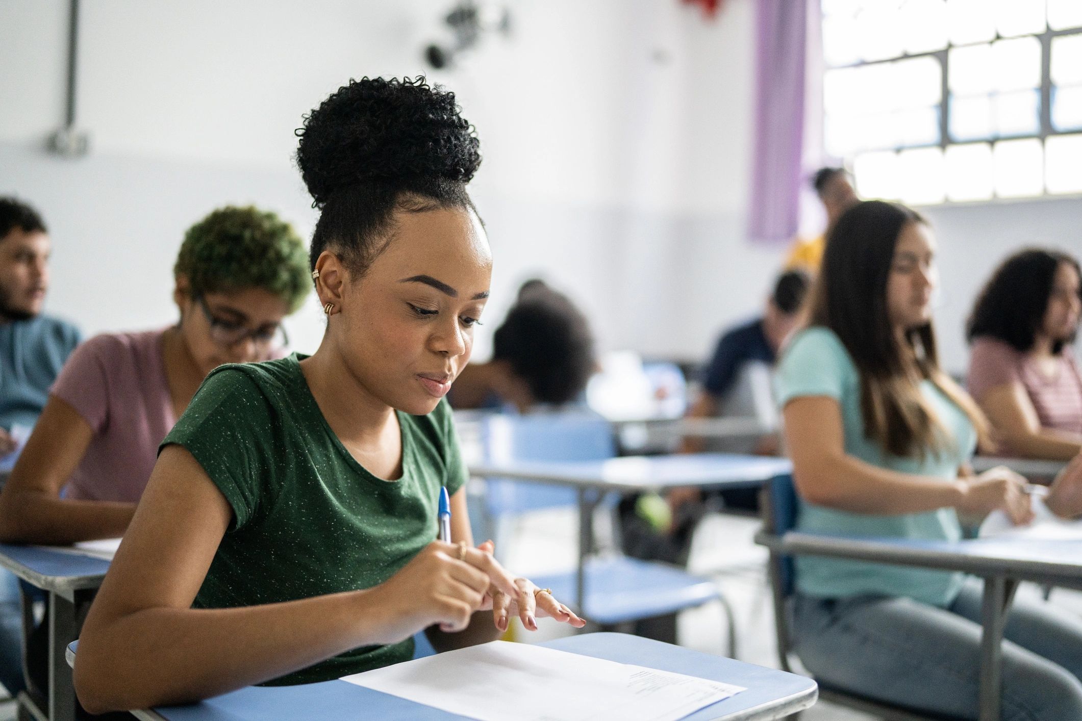 Teen student writing in a classroom