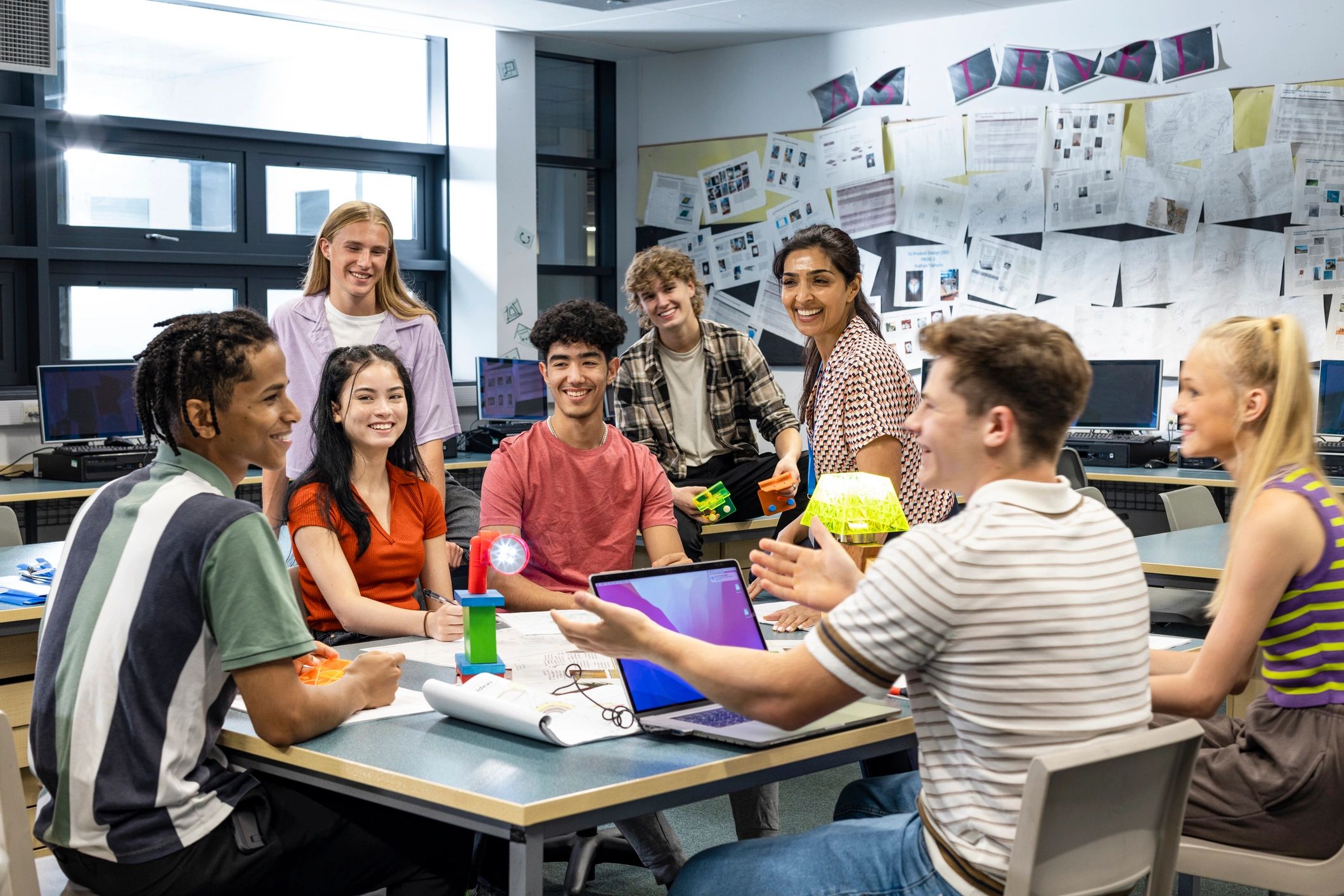 Teacher and high school students collaborating in a classroom