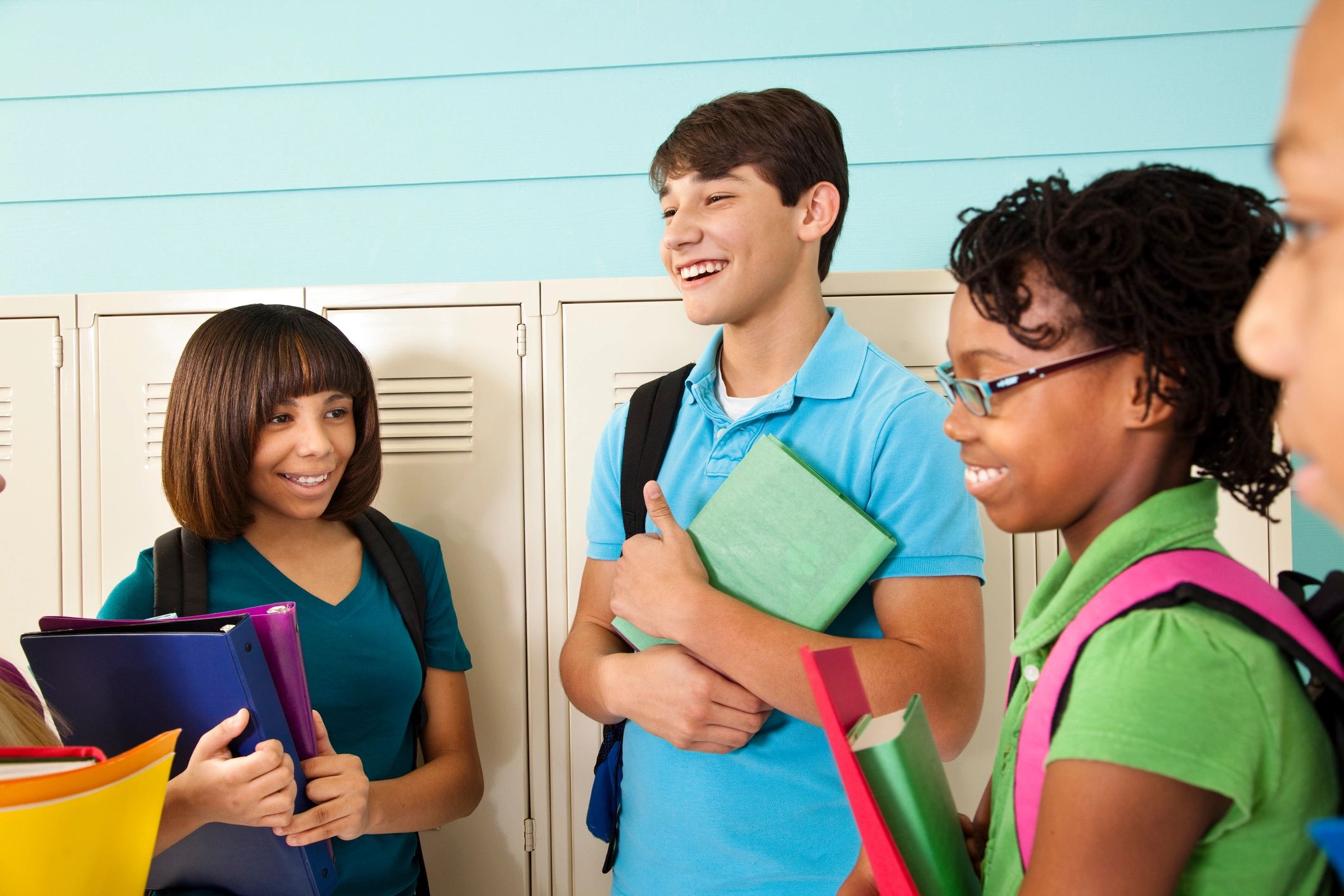 Diverse teenage students talking in a school hallway